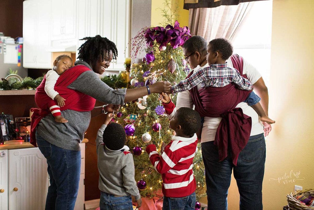 Decorating the tree with baby and toddler wrapped in woven wrap back carries.